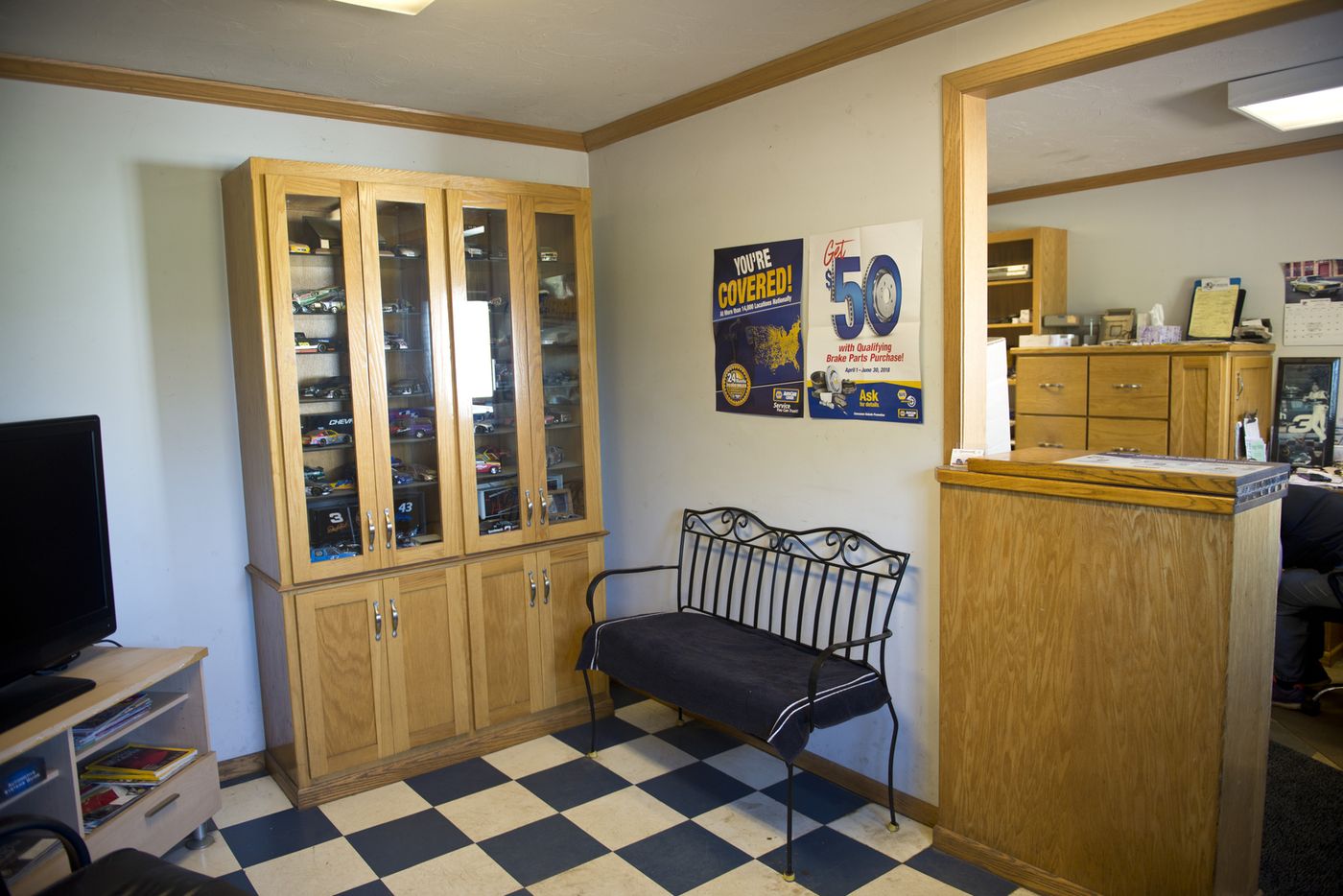 Waiting room with checkerboard floor, model race cars and a black bench